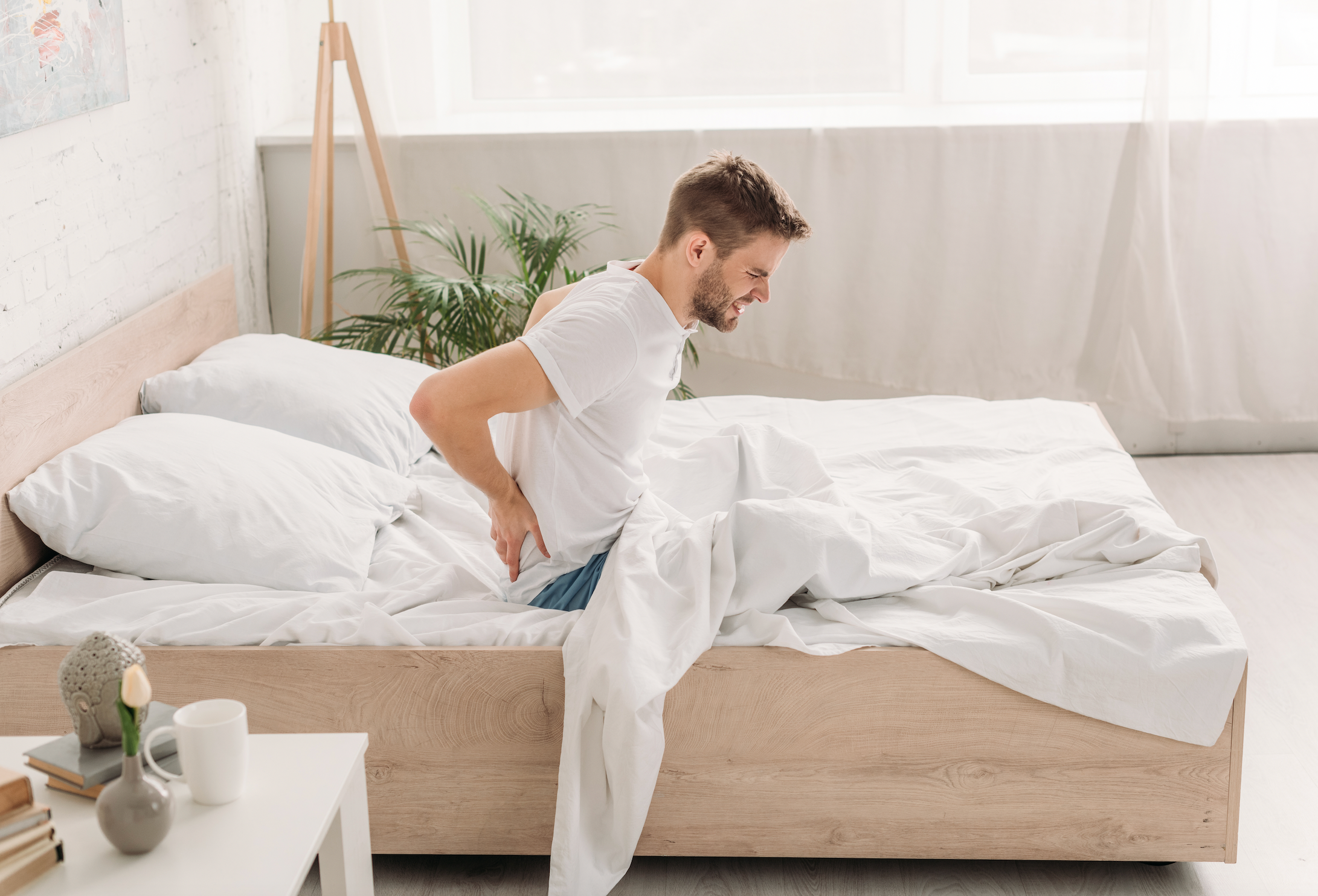 man-experiencing-back-pain-in-bed