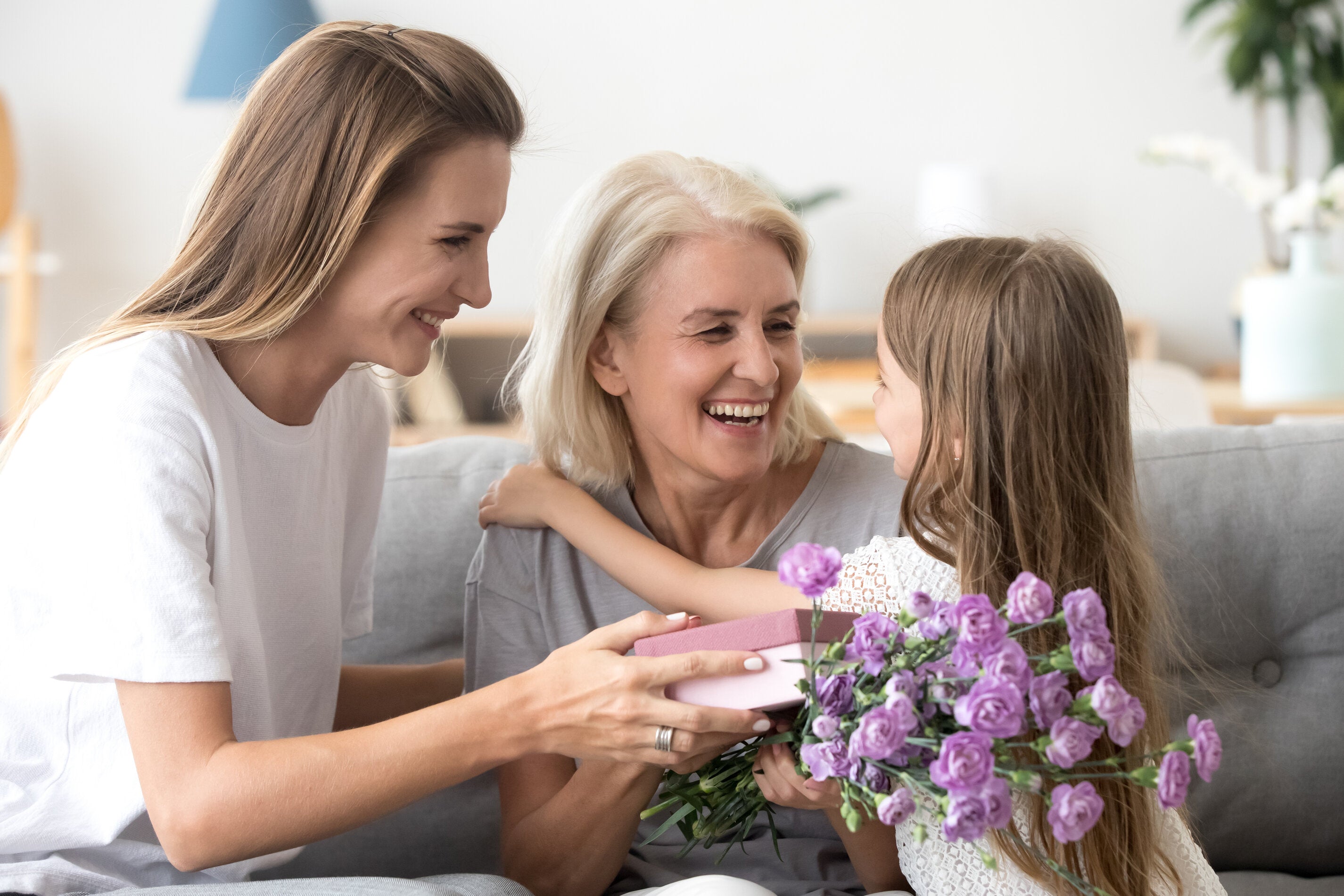 girl and mom giving a gift to grandma
