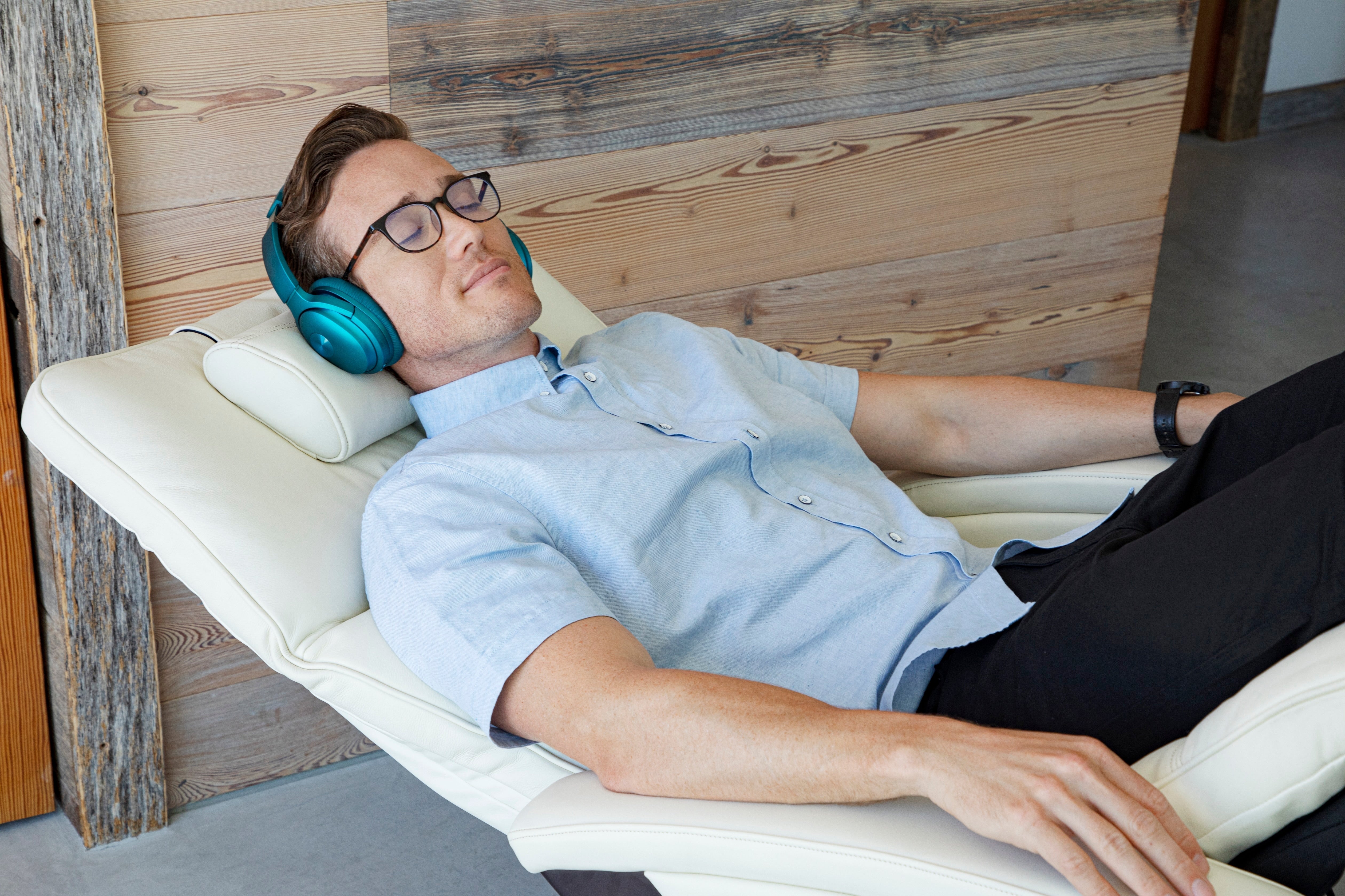 man relaxing in zero gravity chair to relieve body aches from stress