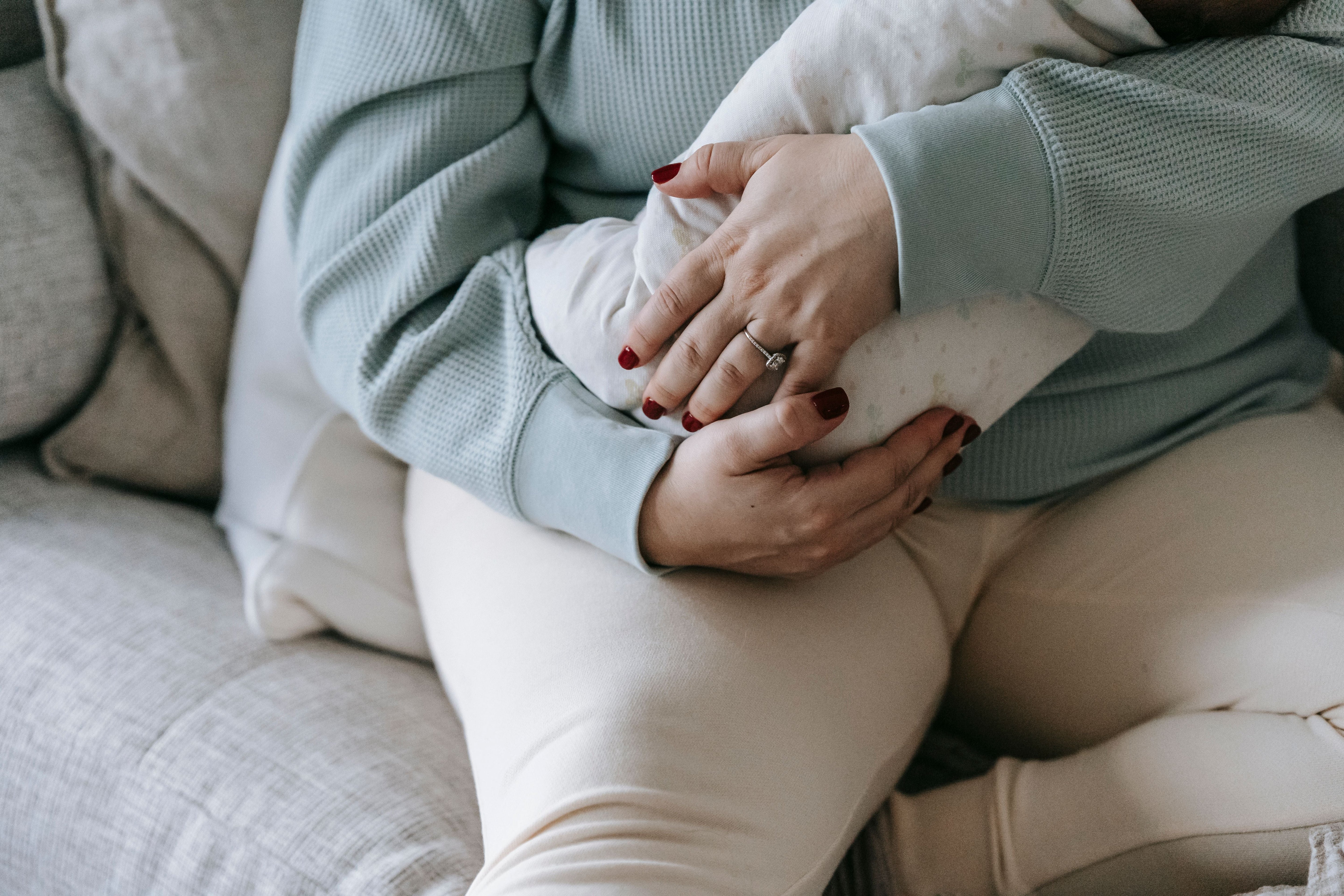 mom holding baby in chair with hip pain after pregnancy