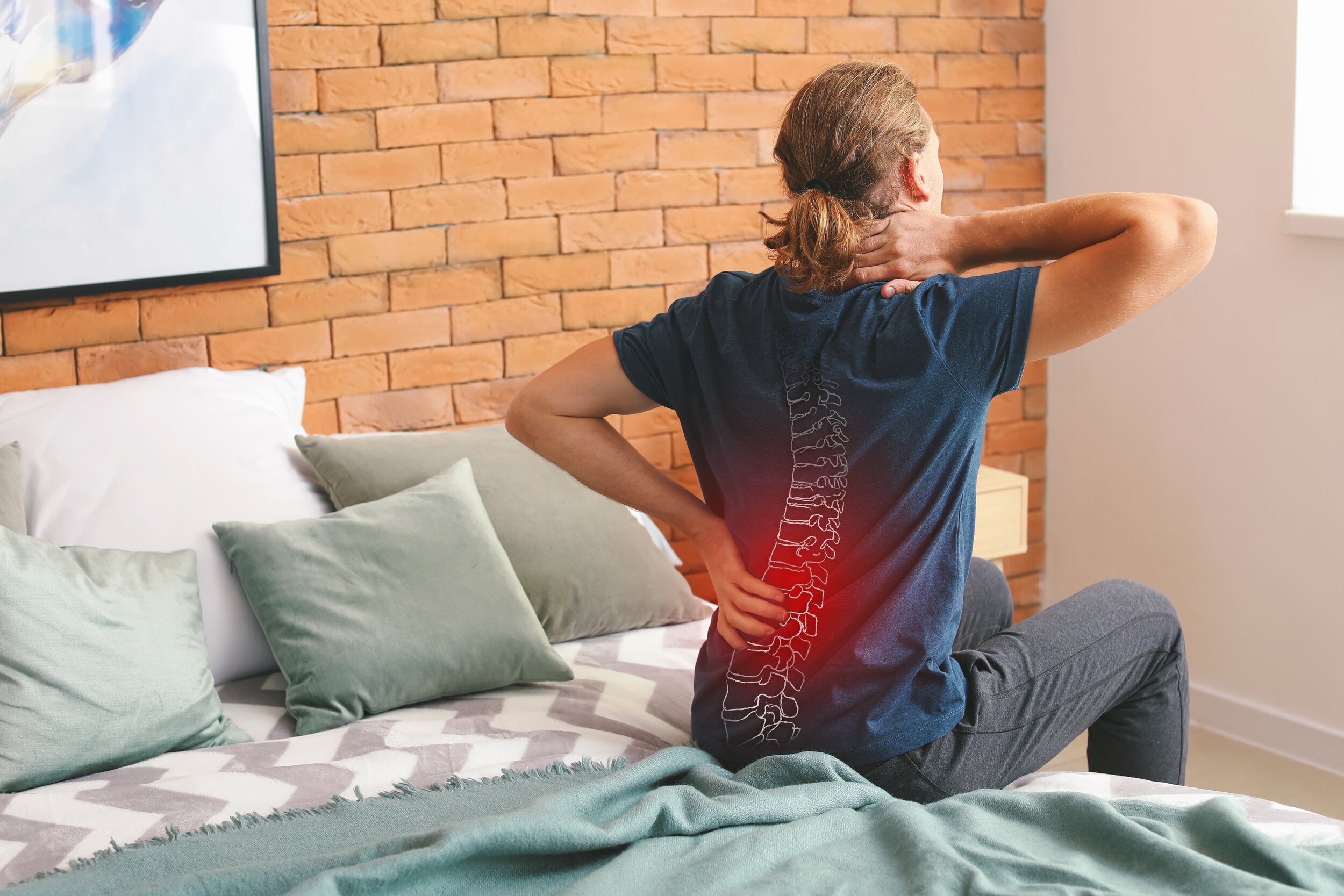 person experiencing spinal pain at home