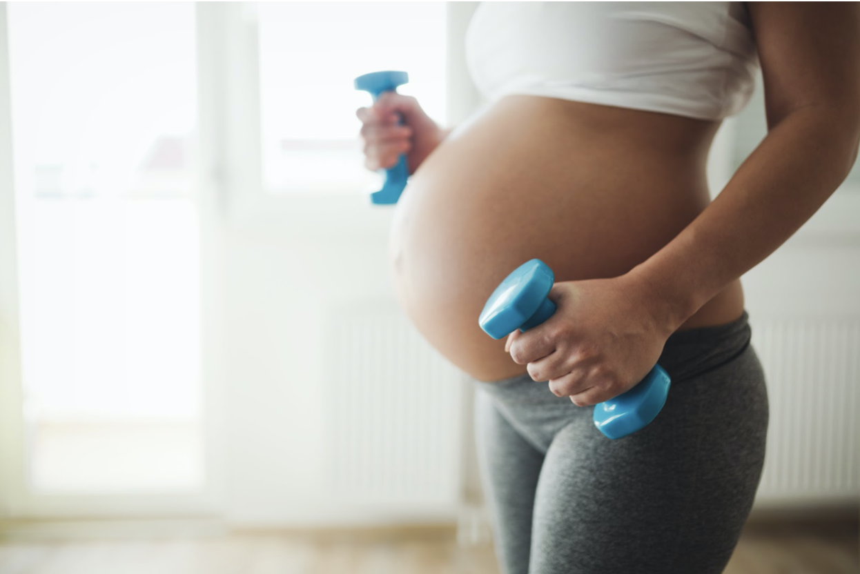 pregnant woman blue dumbbell working out