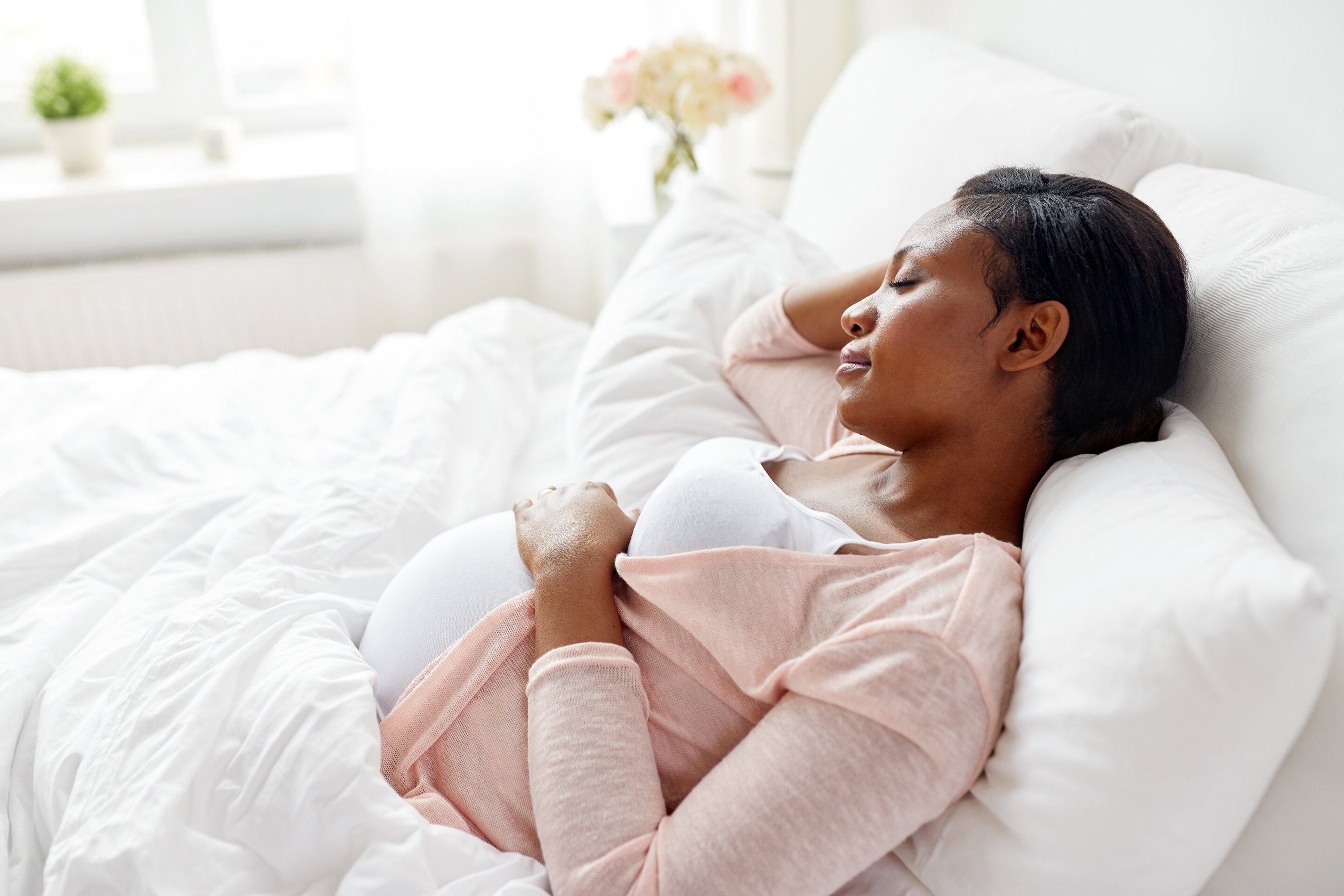 pregnant woman sleeping in bed at home