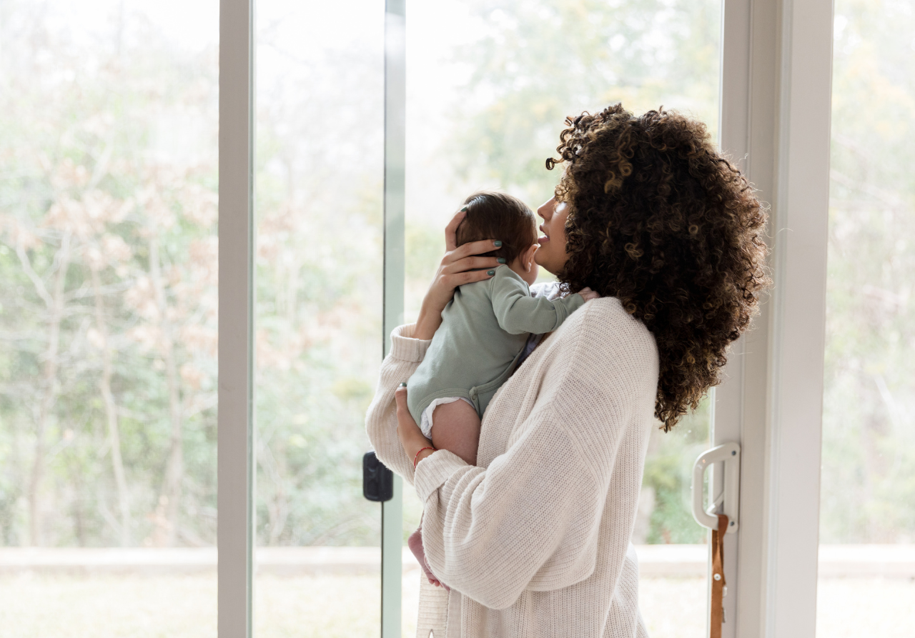 woman with new mom back pain holding baby