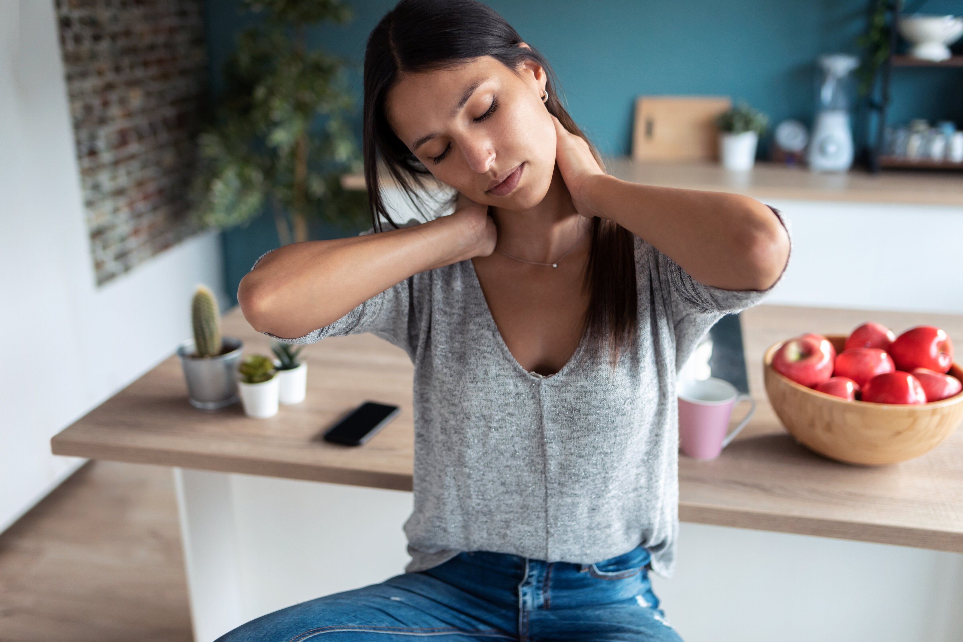 woman experiencing muscle tension in her neck