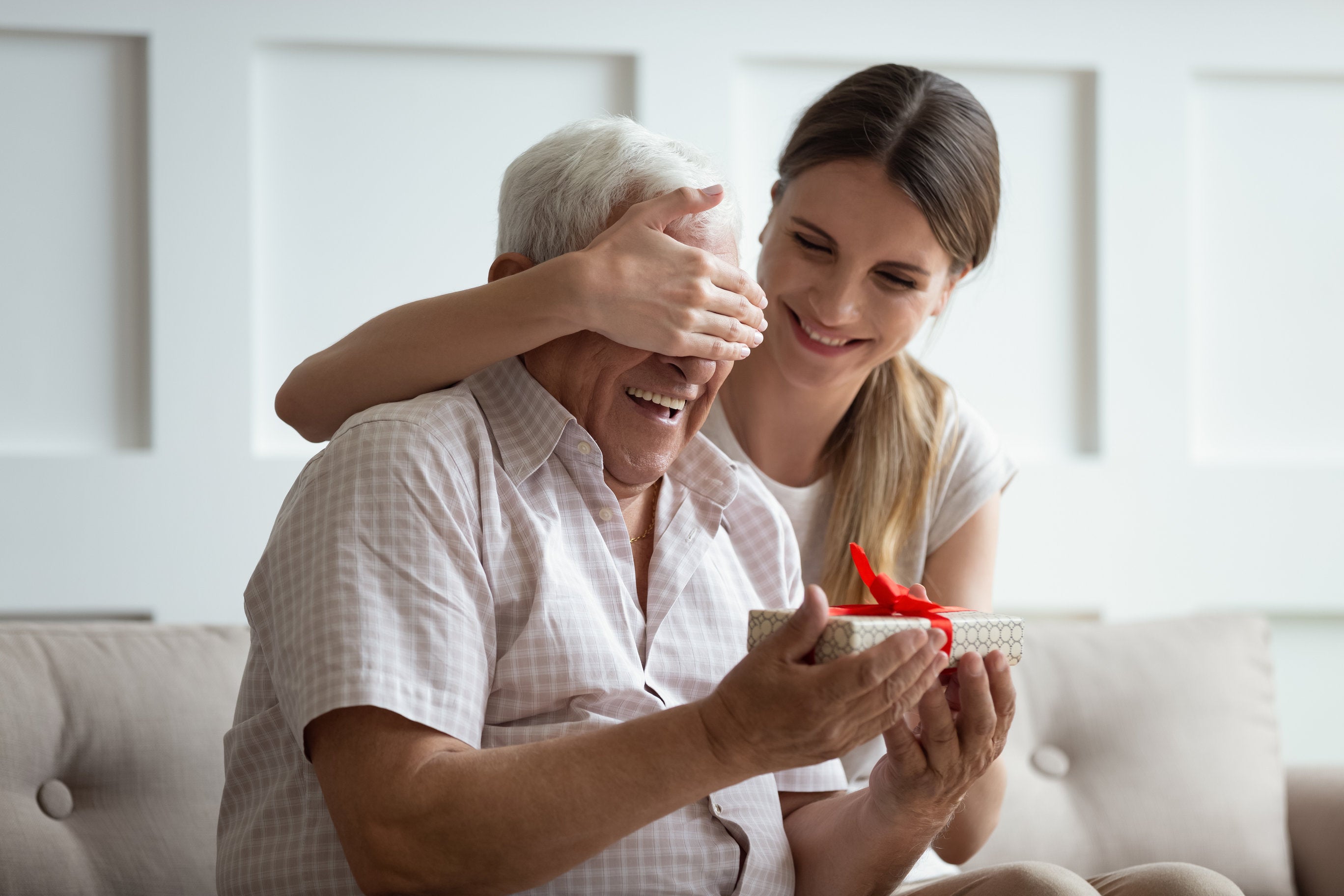 woman giving older father a gift