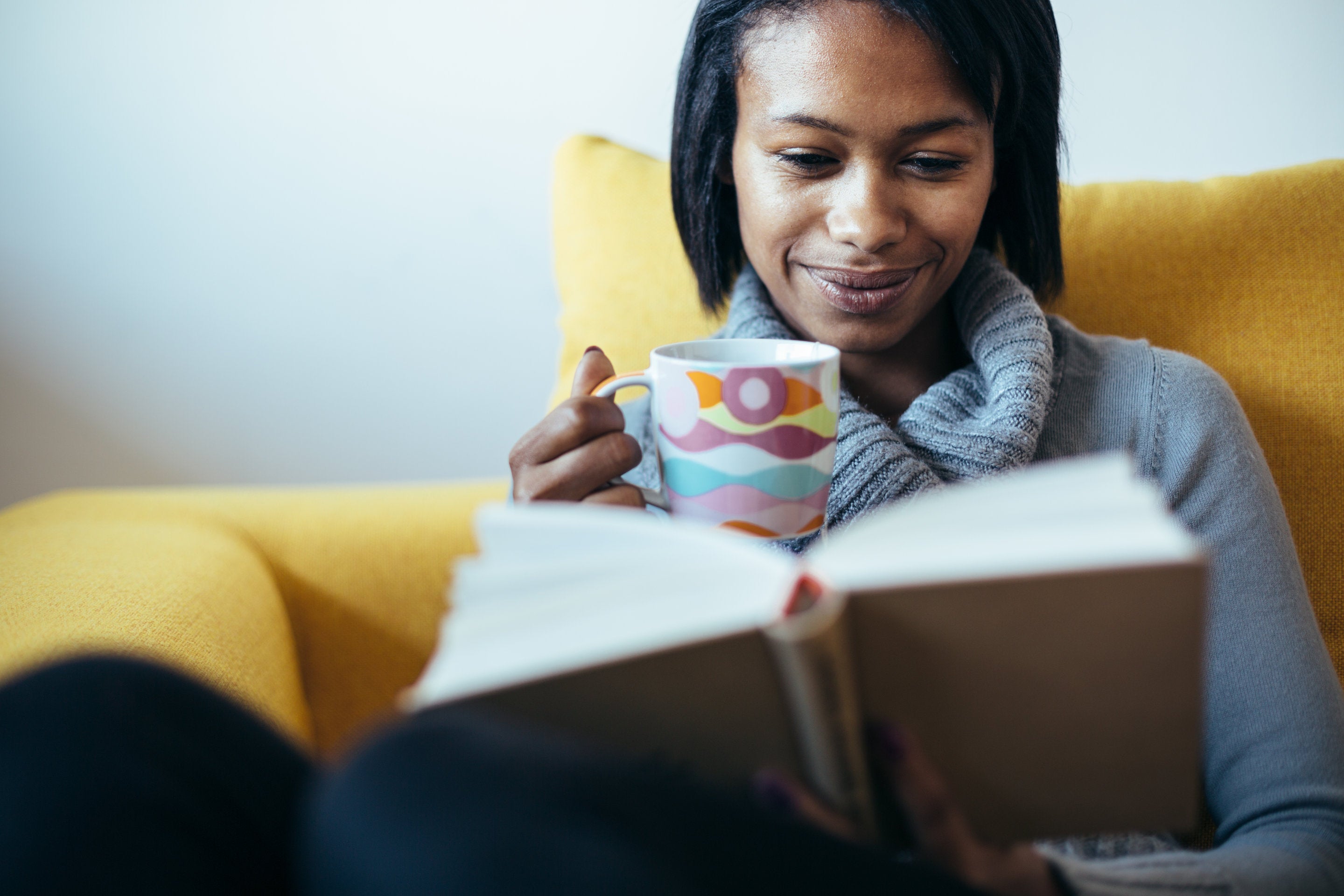woman holding book in reading nook while relaxing in zero gravity chair
