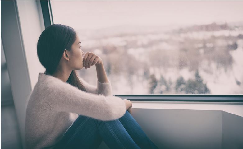 woman at window experiencing the blues