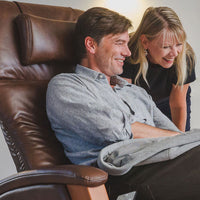 Happy man in Svago recliner, admiring something with a woman.
